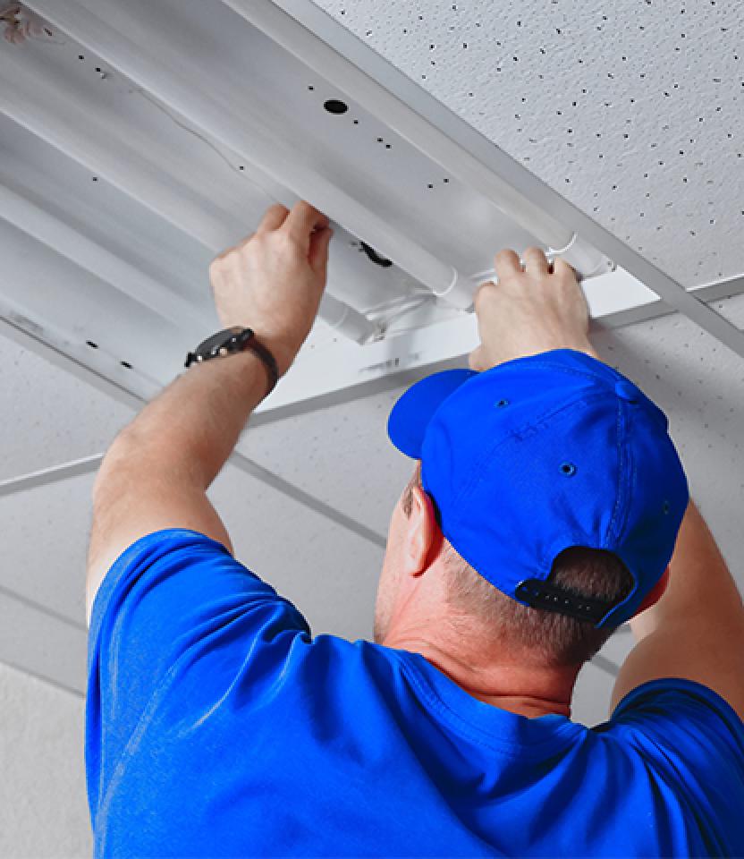 A technician upgrades a fluorescent ballast to an LED one