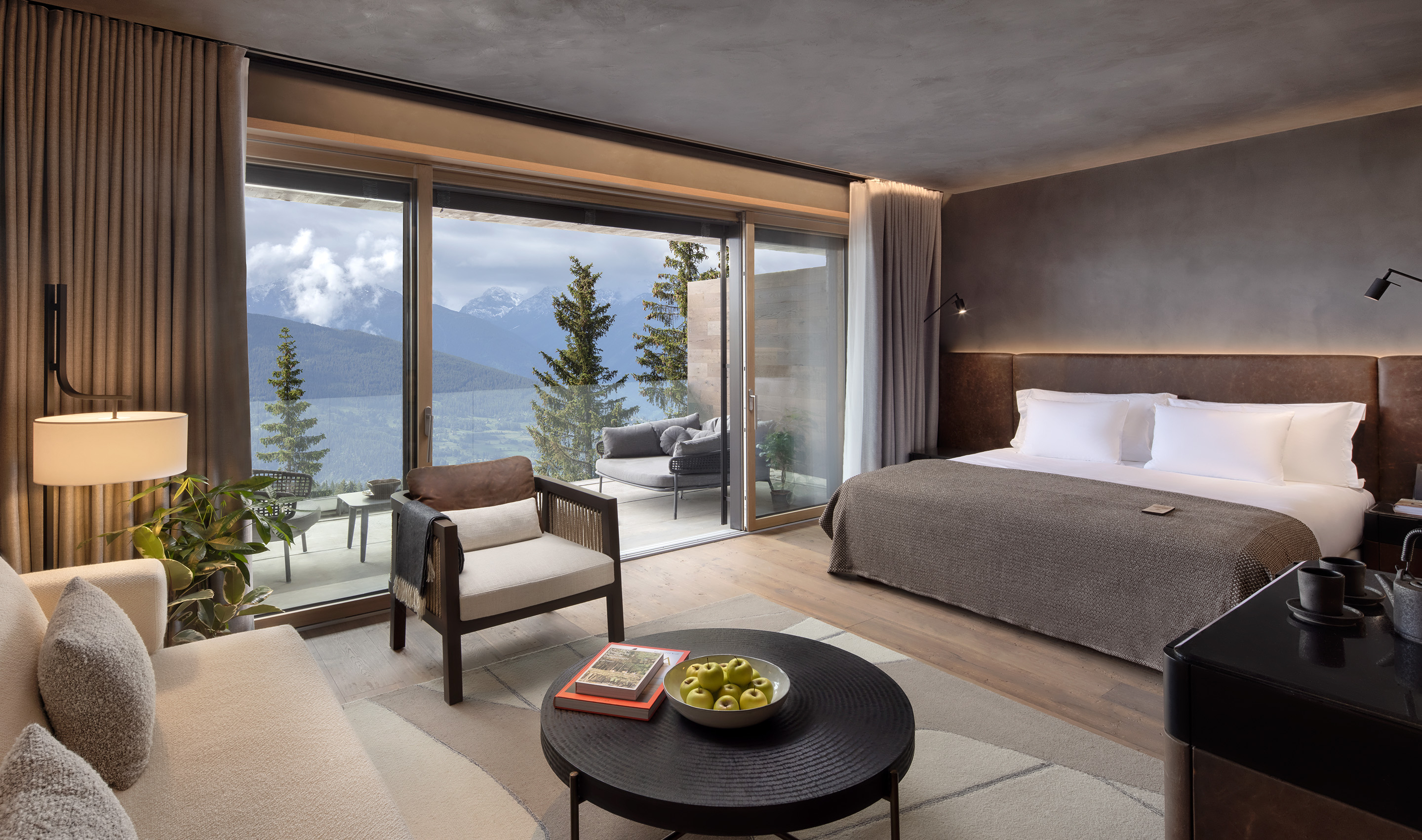 A luxury hotel room at the Six Senses Crans Montana. The drapes are open to reveal a terrace and beautiful view of the mountains. Photography John Athimaritis