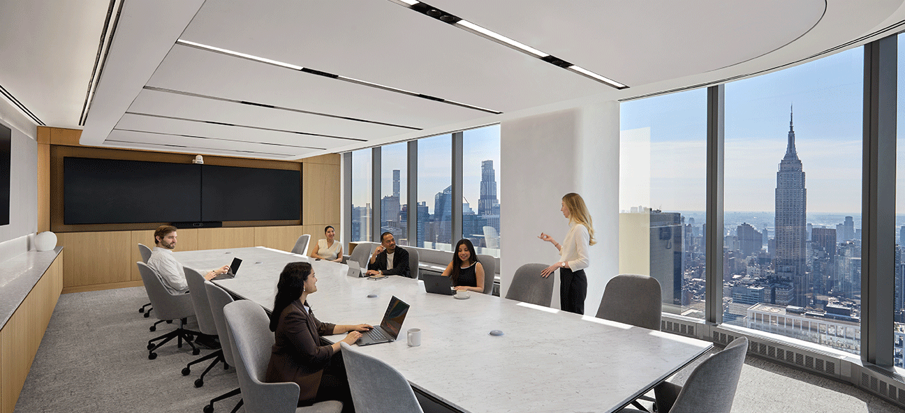A group of people discuss something in an executive boardroom