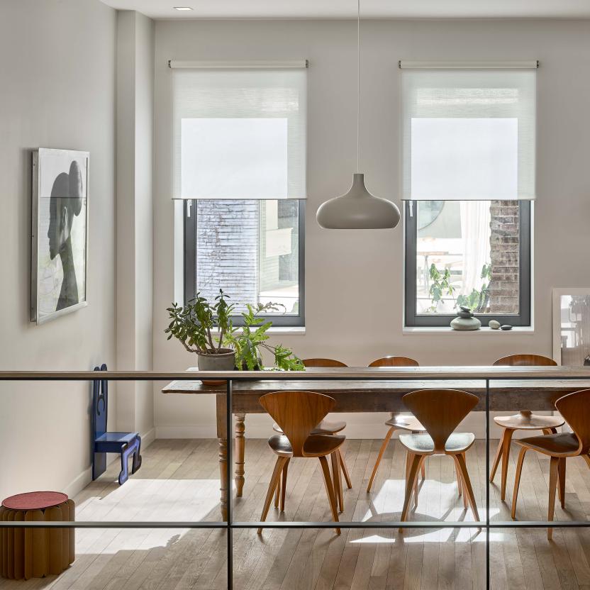 Spacious dining room with automated roller shades filtering natural light