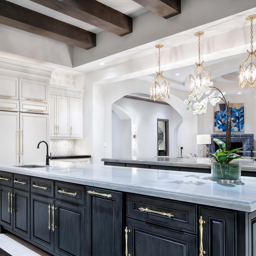  Elegant kitchen with dark cabinetry, marble island, and layered pendant lighting. Photo credit: © Piston Design.