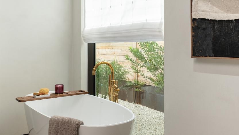 Roman blind made with custom white fabric diffuses daylight and creates privacy in a modern bathroom.