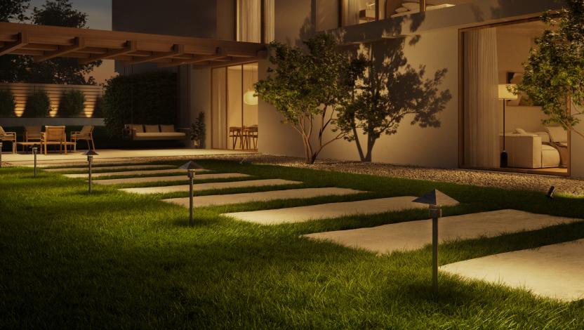 Modern home exterior at dusk with illuminated Lutron x Coastal Source outdoor lighting along a landscaped pathway.