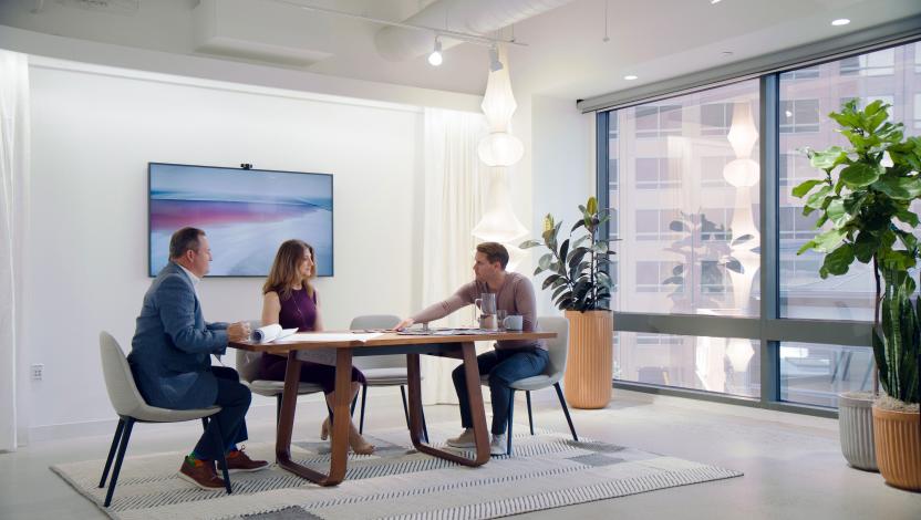 Lutron Dealer meeting with two clients in their office.