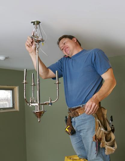 A Pro is on the phone with support while installing a lamp.