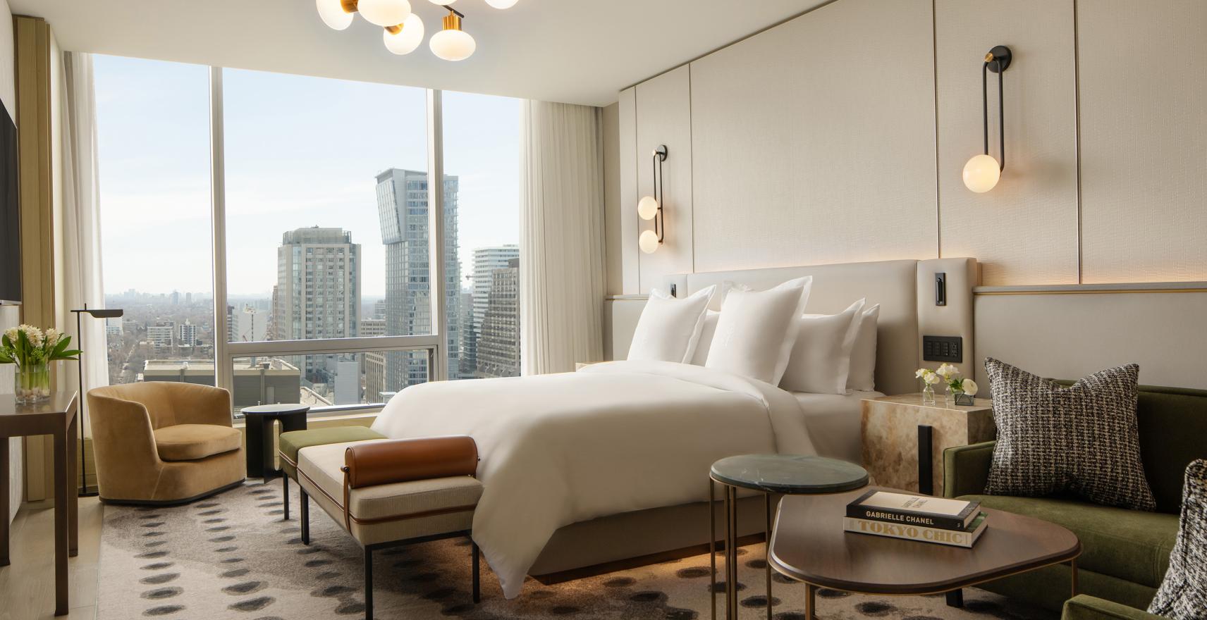 Luxury hotel bedroom with skyline view of a city containing Lutron keypads.
