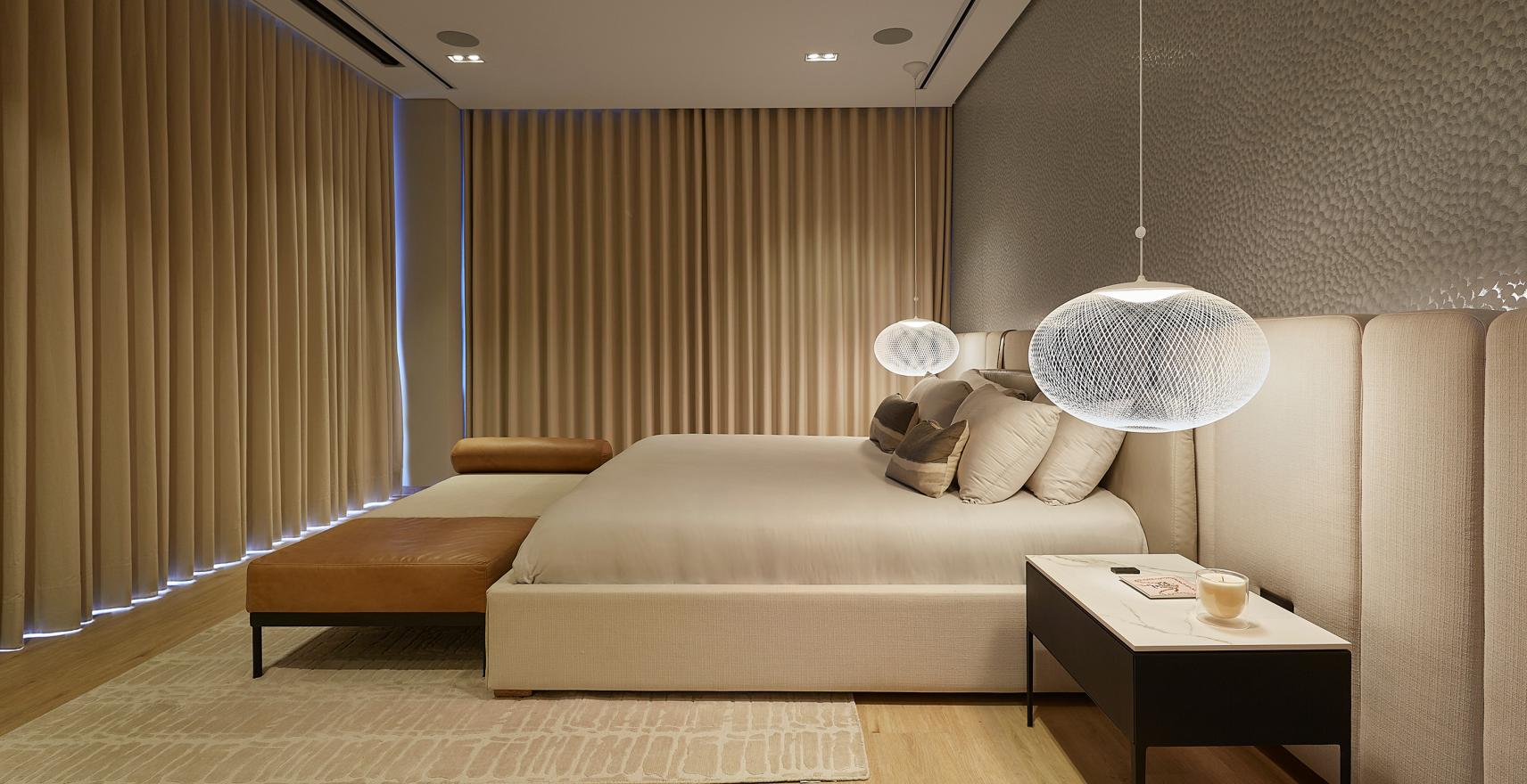 Minimalist bedroom with Lutron drapery tracks, neutral bedding, and clean architectural lines.