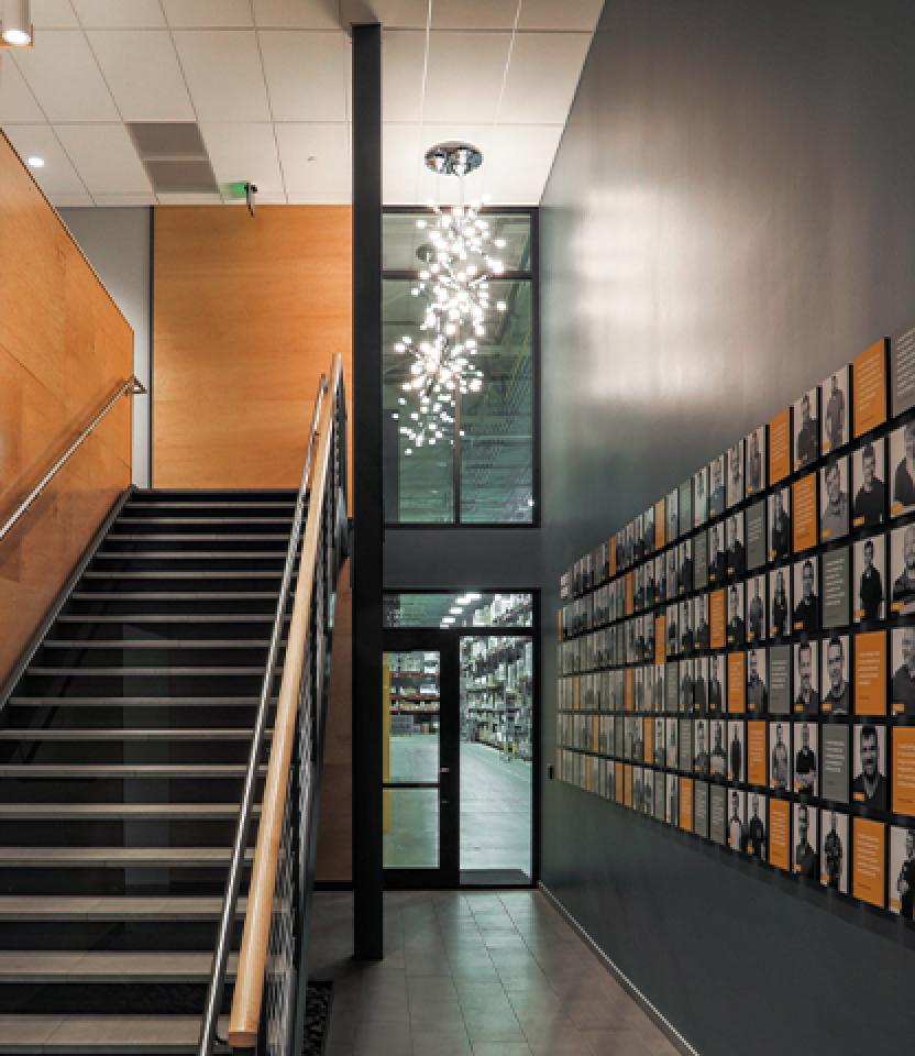 Stairs and corridor with wood and grey paneling and decorative pendant.