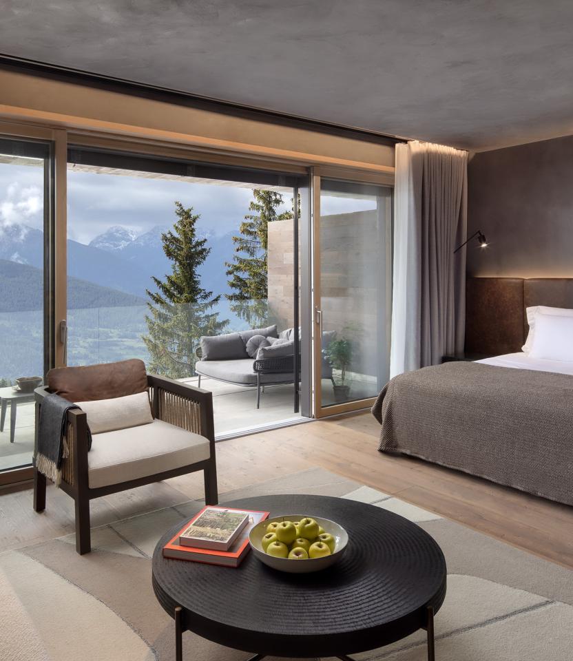 A luxury hotel room at the Six Senses Crans Montana. The drapes are open to reveal a terrace and beautiful view of the mountains. Photography John Athimaritis