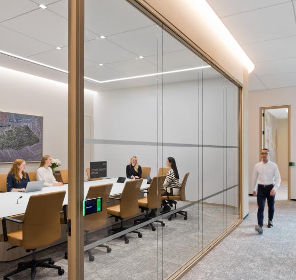 Meeting room with glass partitions and wood accents.