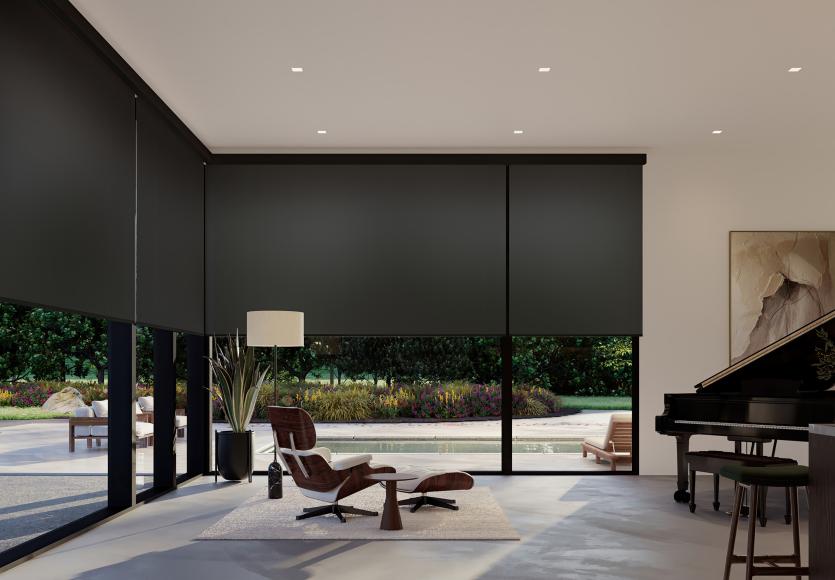 Living room with floor-to-ceiling windows fitted with translucent roller shades that soften daylight while allowing outdoor views.