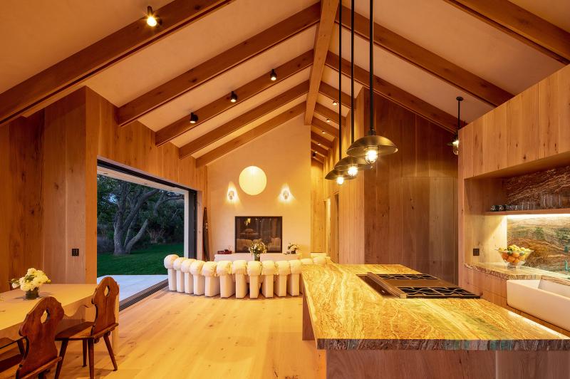 Open kitchen and living space with warm evening lighting, showing how lighting scenes shift with time of day.