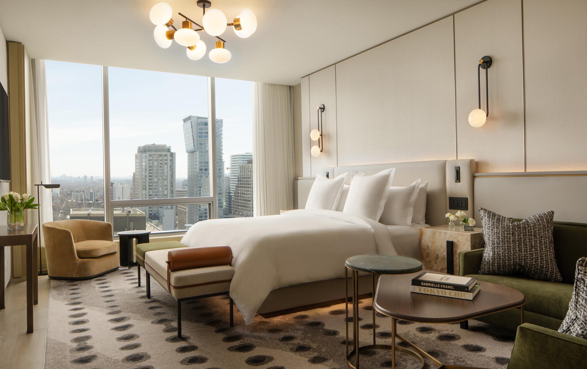 Luxury hotel bedroom with skyline view of a city containing Lutron keypads.