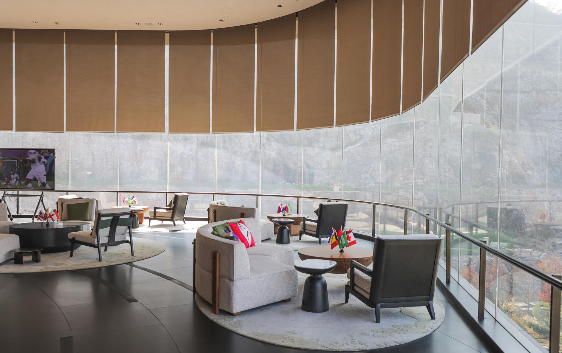 The lobby lounge at the Banyan Tree Nanjing Garden Expo features a curved window wall that hosts more than 13 beige roller shades positioned in perfect alignment.