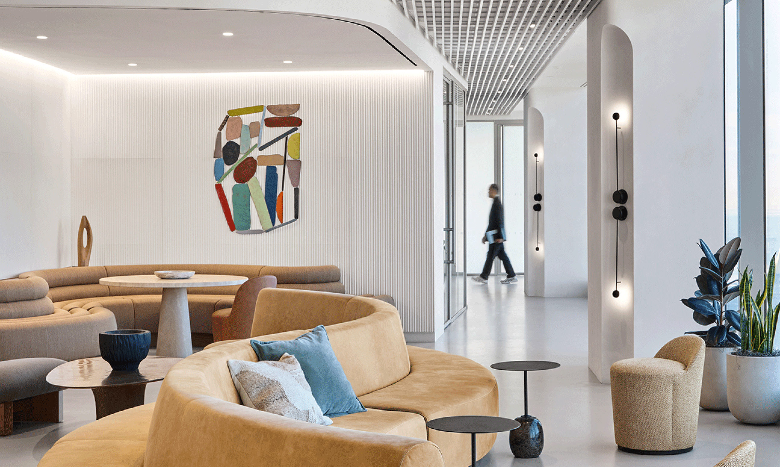 A curving yellow couch and colorful art welcome visitors into a modern office